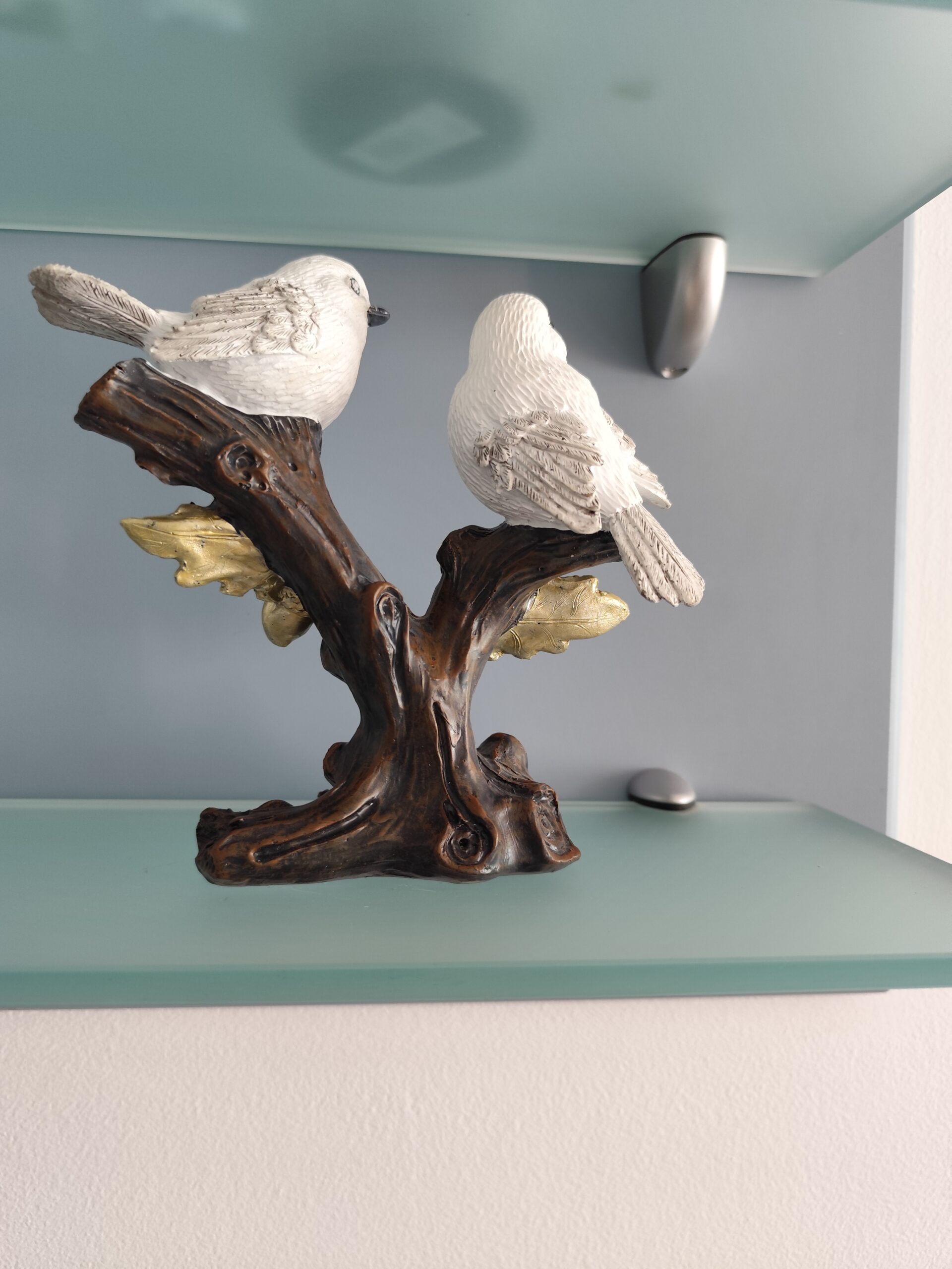 Rear view of the decorative resin figurine featuring two white birds and a detailed dark branch