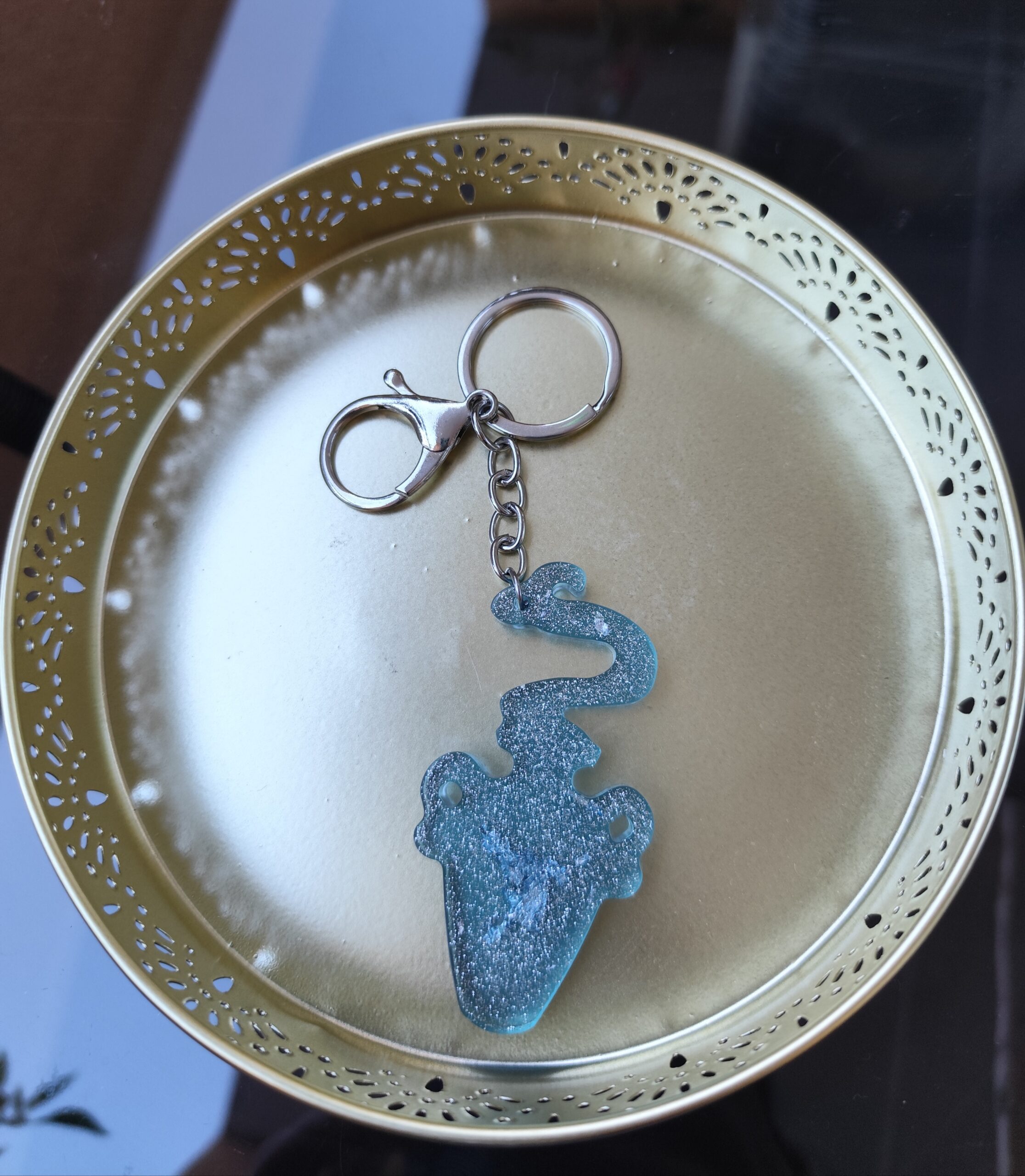 Handmade Aquarius zodiac Water Bearer keychain in light blue epoxy resin with silver glitter