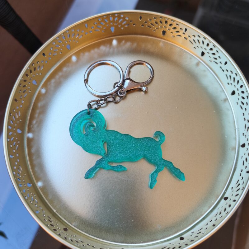 Handmade Aries zodiac ram keychain in green epoxy resin with glitter