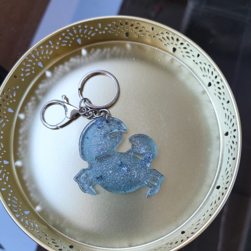Handmade Cancer zodiac crab keychain in light blue epoxy resin with silver glitter