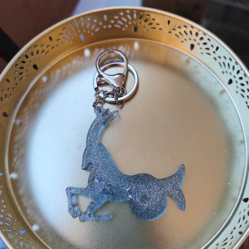Handmade Capricorn zodiac goat keychain in light blue epoxy resin with silver glitter