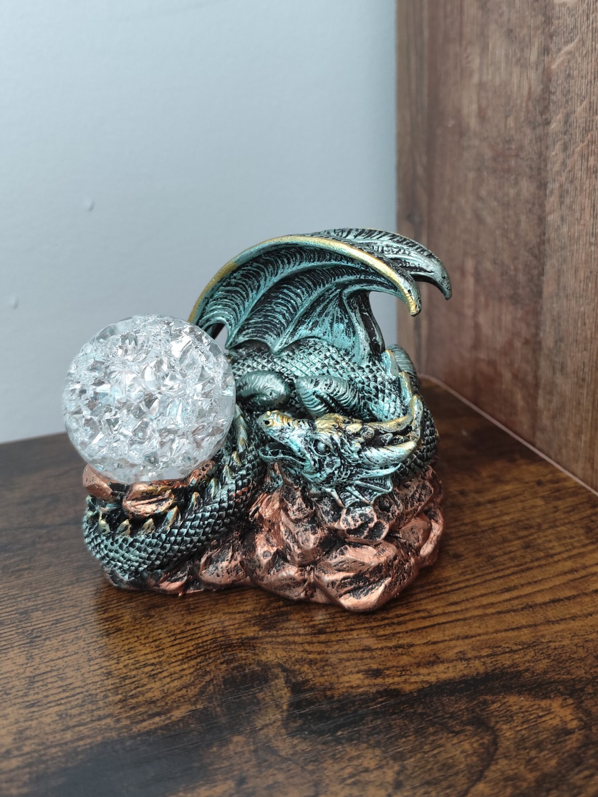 Fantasy dragon figurine holding a faceted crystal-style crystal ball