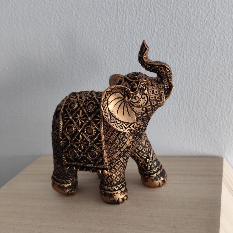 Ornate resin elephant figurine with an antique bronze and gold-tone finish