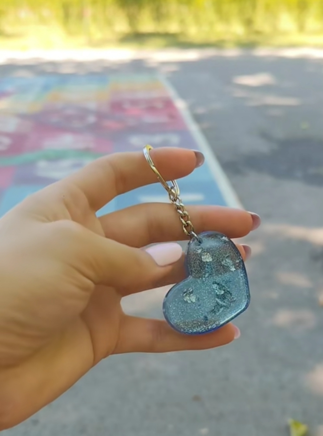 Close-up of a sparkling blue epoxy resin heart keychain with decorative details