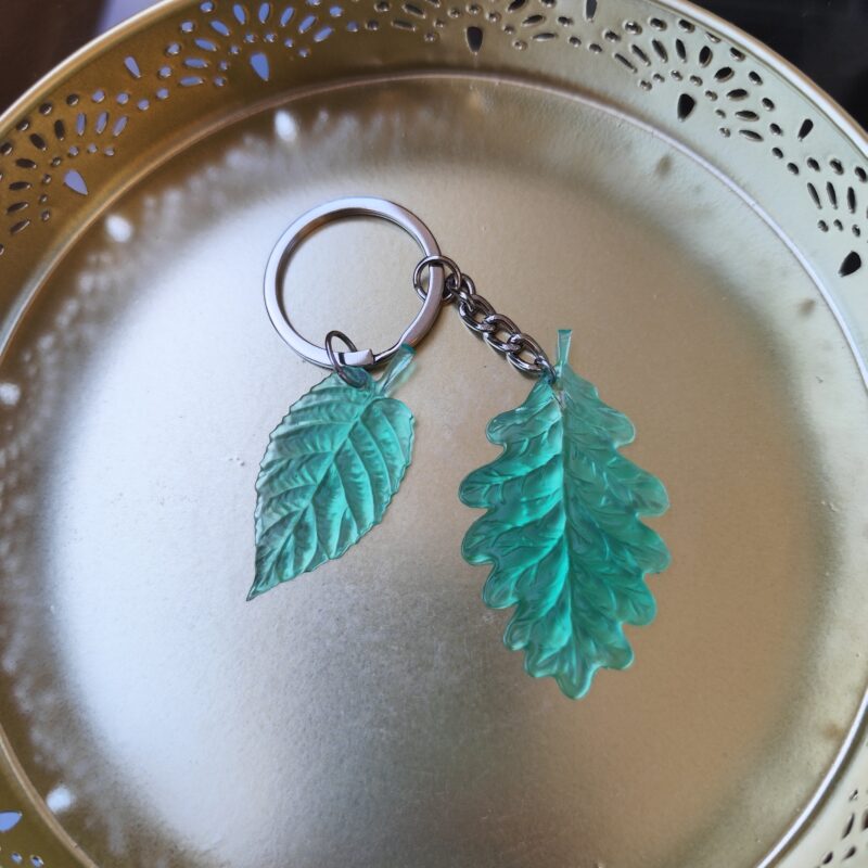 Handmade teal leaf epoxy resin keychain with detailed botanical design and silver-tone keyring