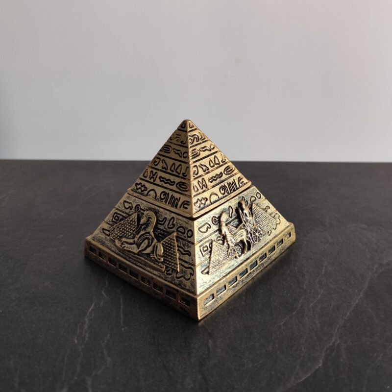 Antique gold Egyptian pyramid with detailed hieroglyphic reliefs