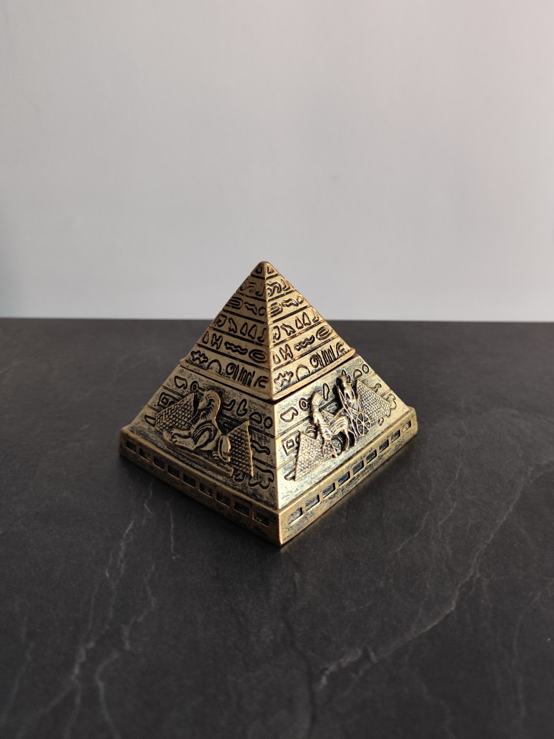 Antique gold Egyptian pyramid with detailed hieroglyphic reliefs